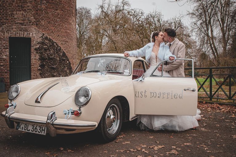 Romantisches Brautpaarschooting vor einem Schloss mit Porsche